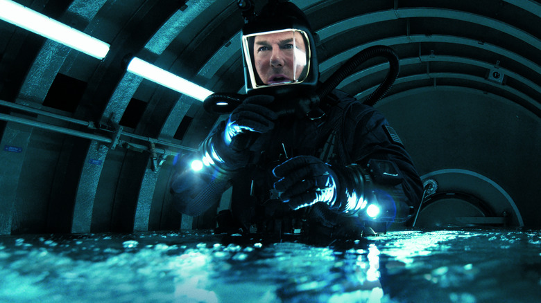 Tom Cruise en tant qu'Ethan Hunt s'approvisionne dans un équipement de plongée de haute technologie dans un sous-marin coulé dans Mission: Impossible - The Final Reckoning