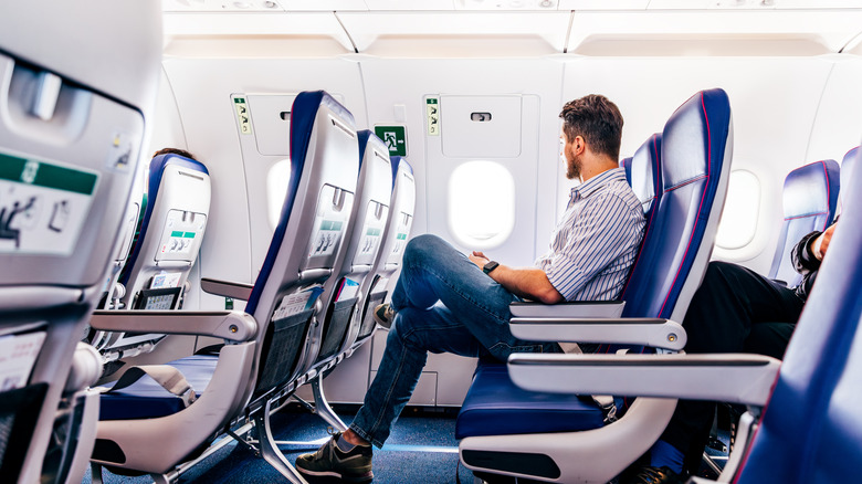 Un homme assis dans un siège d'avion en regardant par la fenêtre