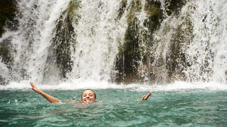 Jeune voyageur nageant près de la cascade