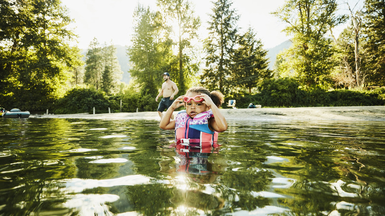 Enfant portant un gilet de sauvetage dans une rivière