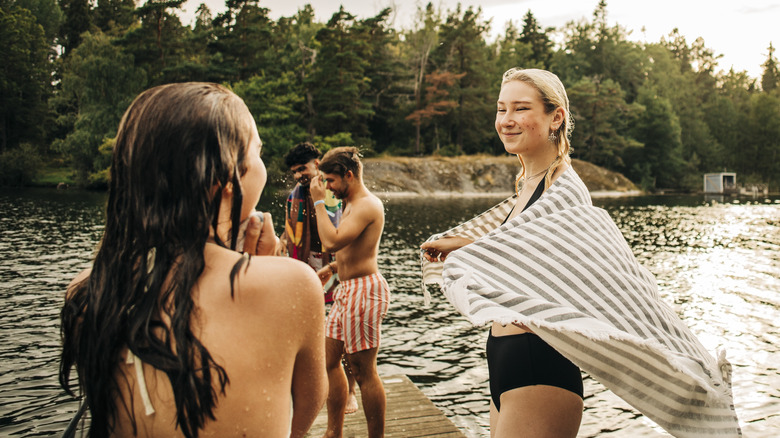 Des amis souriants debout sur le bord du lac