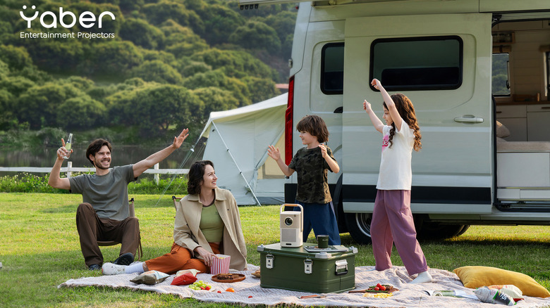 RV Famille dansant autour du projecteur de la série Yaber T2