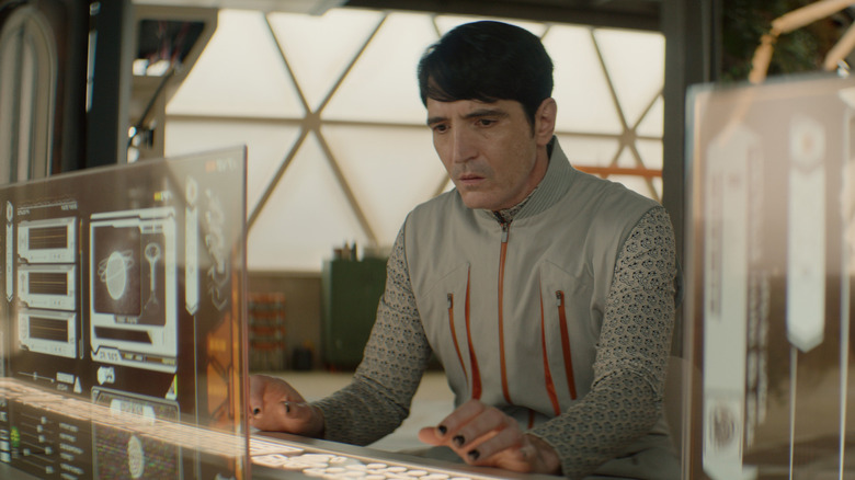 David Dastmalchian en tant que Gurathin tapant sur son ordinateur à Murderbot
