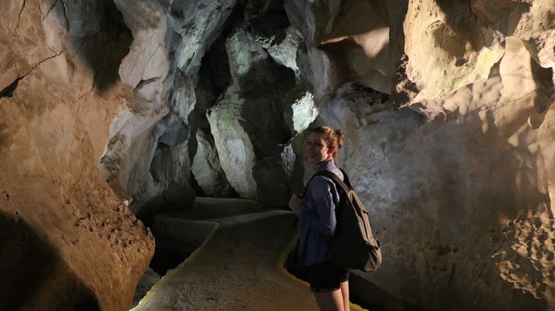 Une jeune femme se tient dans une grotte à Viñales, Cuba