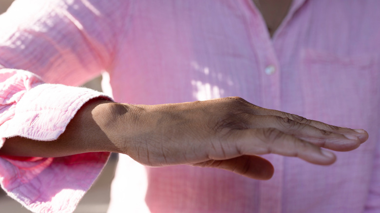 Femme tenant sa main devant son corps