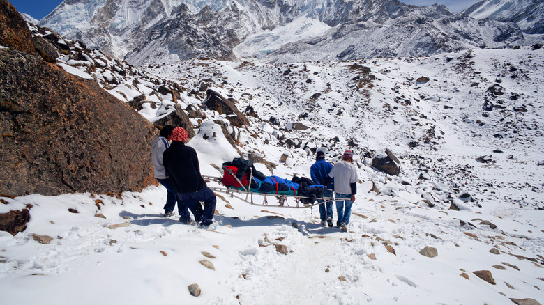 Équipe de sauvetage et grimpeur blessé sur la pente