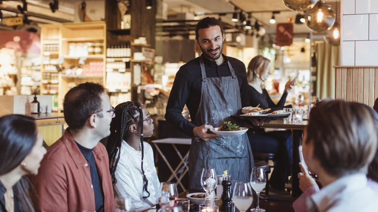 Un serveur sert un groupe de jeunes