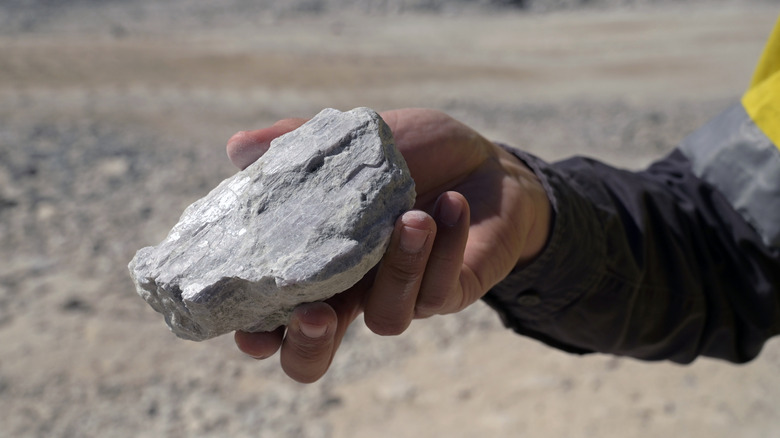 Un rocher riche en lithium est tenu par un mineur