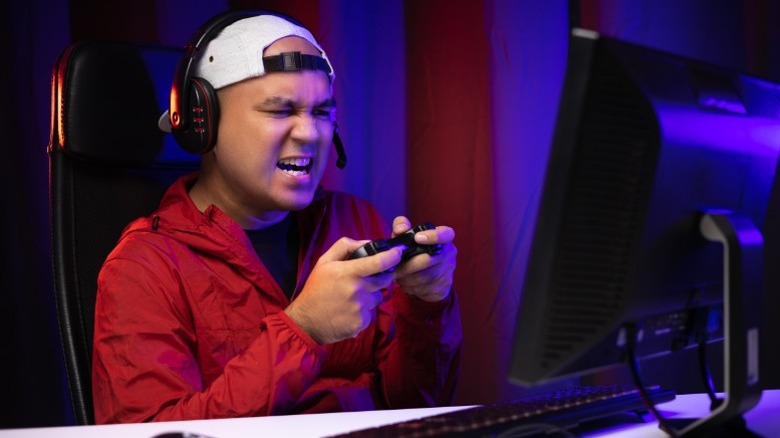 Des gars frustrés visiblement jouant à des jeux vidéo sur un PC