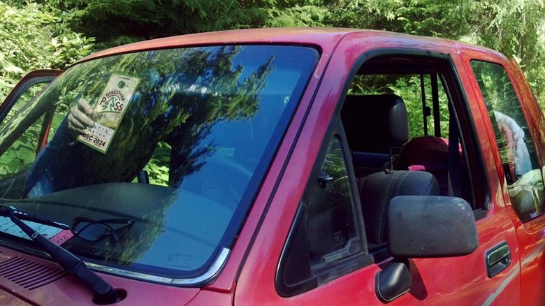 Un homme est suspendu une passe de découverte de l'État de Washtingston dans sa camionnette rouge