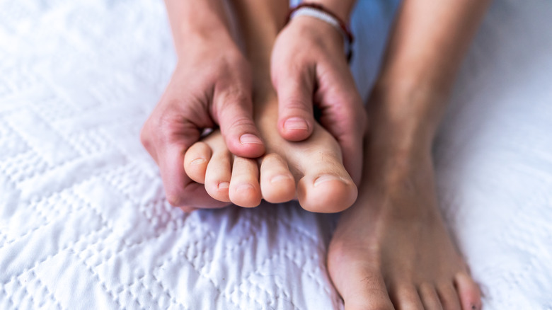 Mains massageant les pieds nus