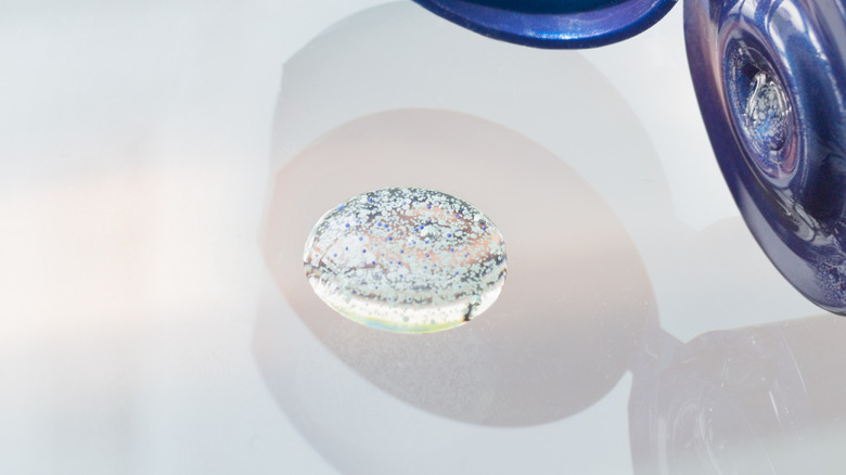 Les microbilles sont vues suspendues dans un liquide assis sur une surface blanche