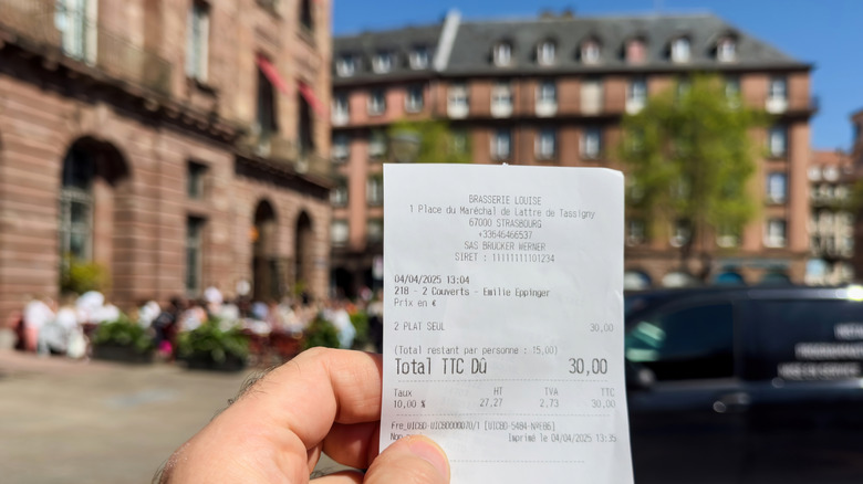 Une main tenant un reçu imprimé en France