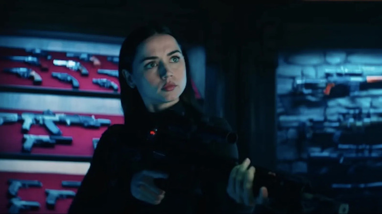 Ana de Armas brandisse un pistolet dans une salle avec des armes à feu comme Eve Macarro dans Ballerina