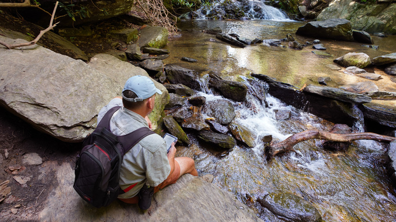 L'homme se détendant en randonnée à Catawba Falls près de Old Fort, Blue Ridge Mountains, Caroline du Nord.
