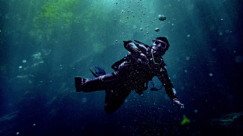 Diver de plongée nageant à travers des grottes sous-marines