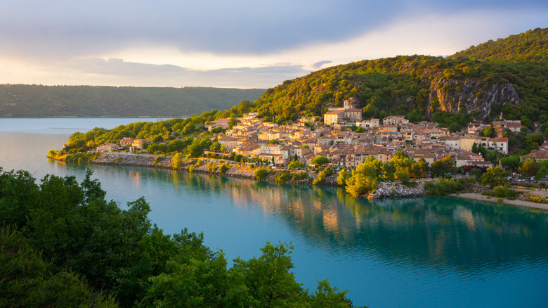 Village à flanc de colline avec des toits carrelés sur les rives d'un lac bleu