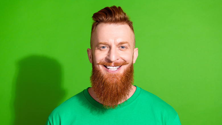 Un homme aux cheveux roux avec une longue barbe sourit