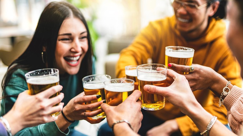 Un groupe de jeunes profite d'un toast de verres de bière