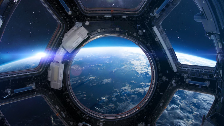 Une fenêtre de la station spatiale regardant la Terre