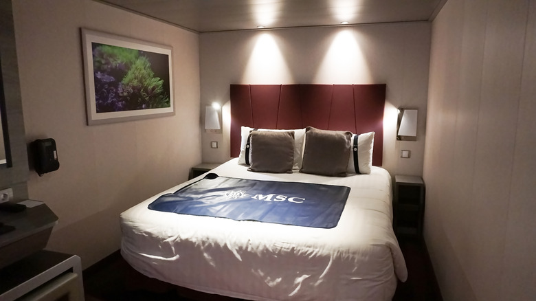 Les lumières illuminent un lit dans une cabine de navire de croisière