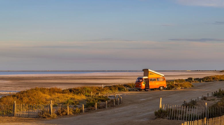 Van de camping garé près de la plage au coucher du soleil