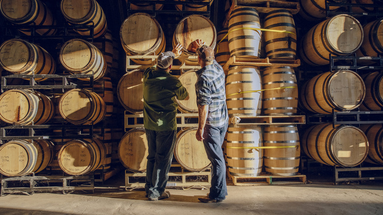 Deux personnes admirant un baril de whisky
