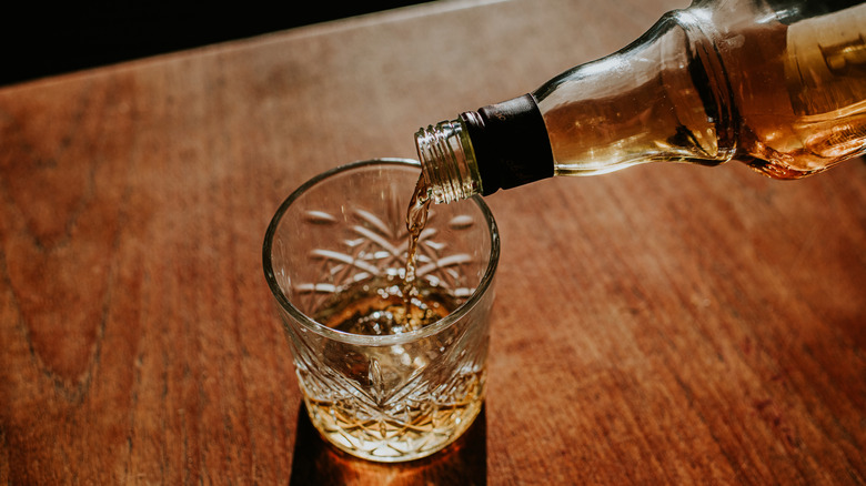 Bouteille de whisky versant dans le verre