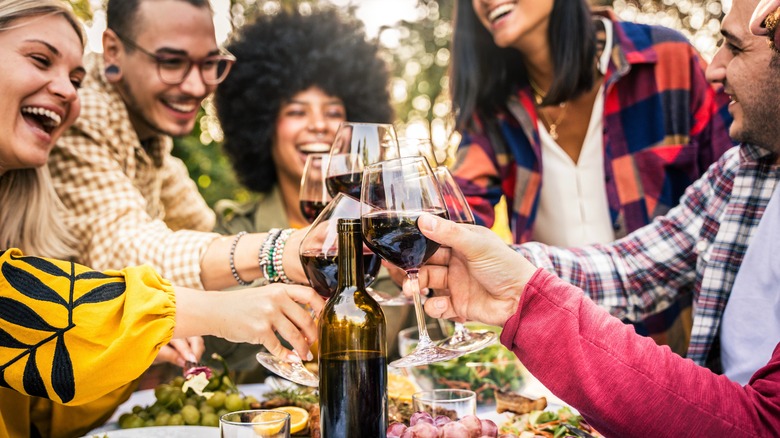 Un groupe de convives toaste leur glasse à vin