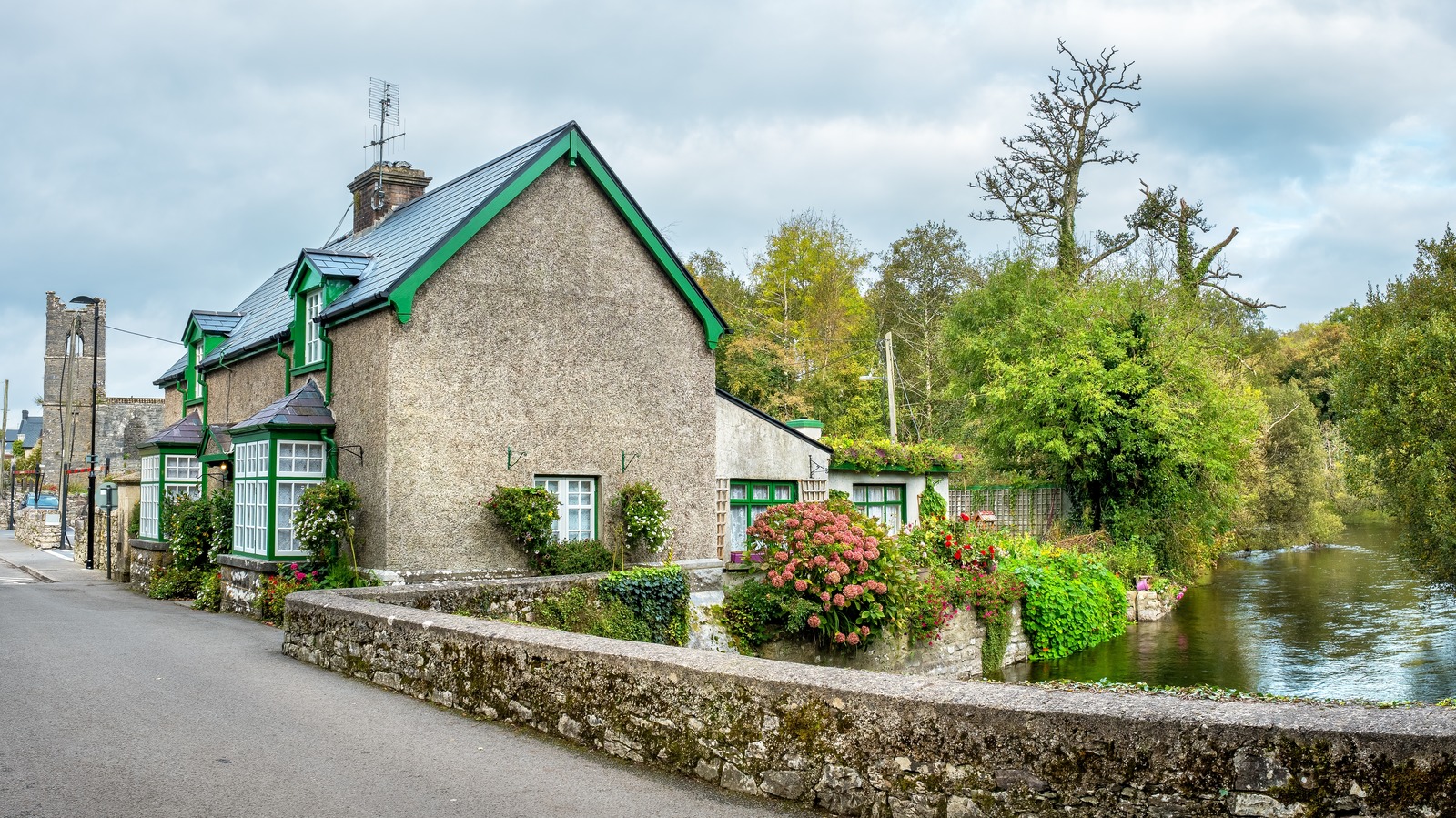 Un village irlandais avec des chalets de chaume propose des promenades à cheval le long des lacs sereins
