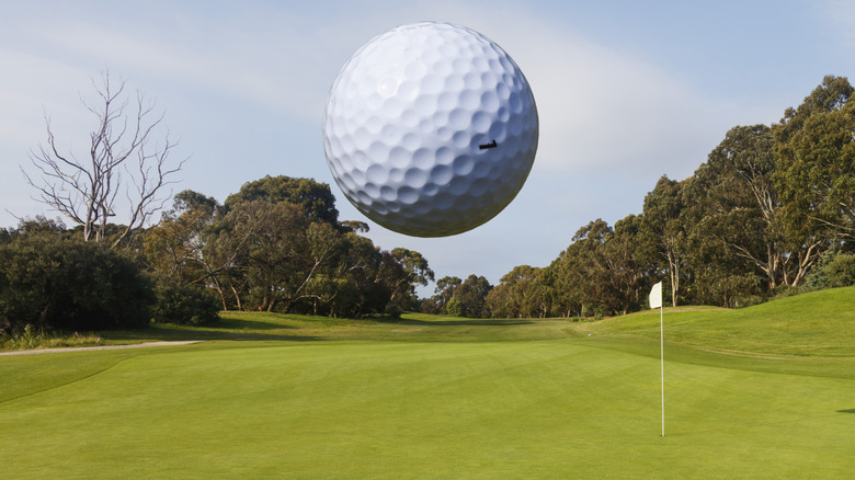 Balle de golf volant en l'air vers une épingle et un trou