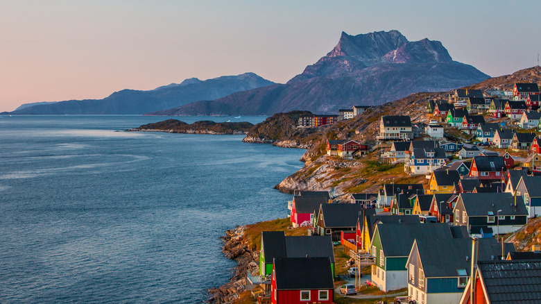Maisons colorées sur la côte avec des montagnes au loin