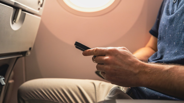 Homme utilisant le téléphone dans l'avion