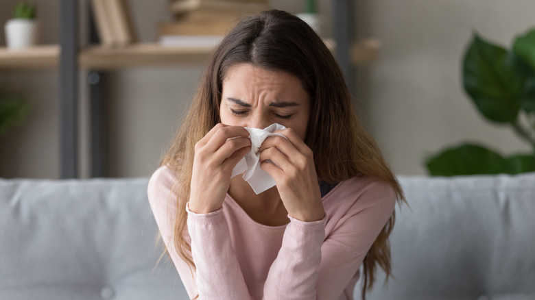 Femme soufflant le nez avec un tissu