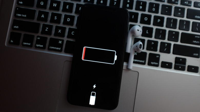 iPhone sur un clavier MacBook montrant une icône à faible batterie