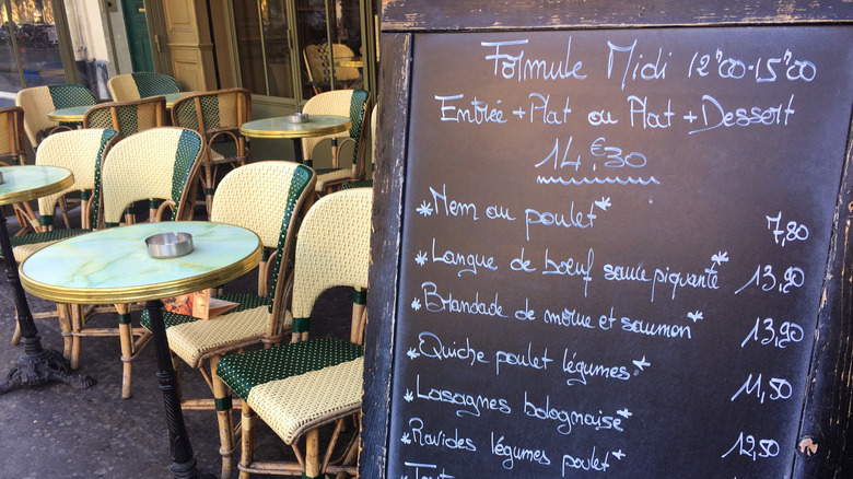 Une planche à sandwich présente des éléments de menu en français