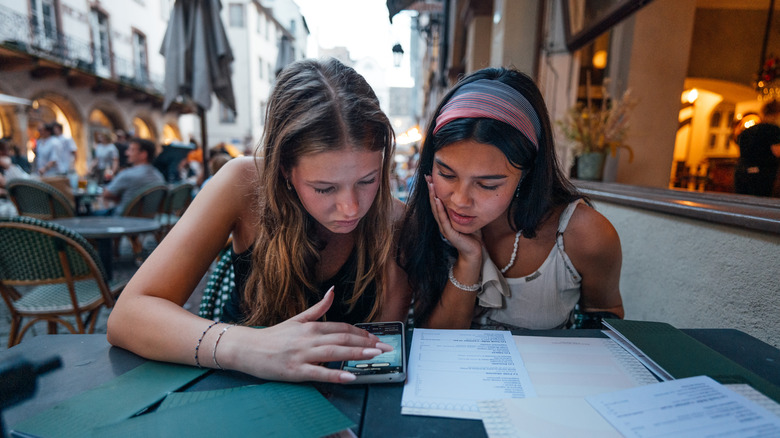 Deux jeunes voyageurs se porent sur un menu dans un restaurant européen