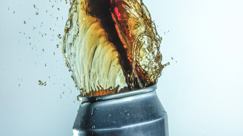 Soda explosant du haut d'une boîte ouverte