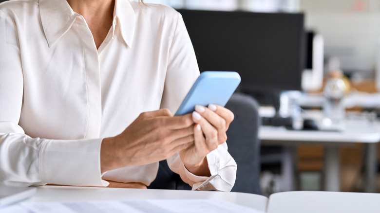 Femme utilisant le téléphone sur Work Desk