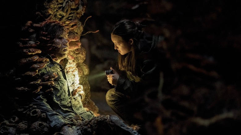 Ellie regardant les zombies spores avec une lampe de poche dans le dernier de nous