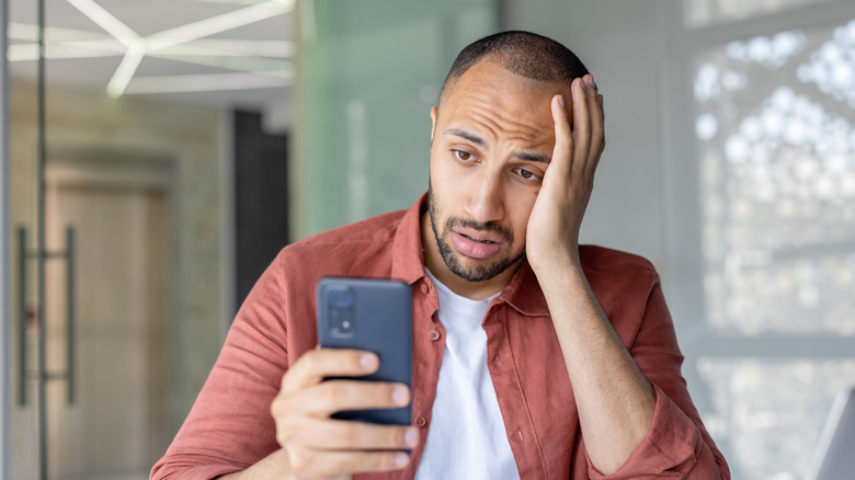 Homme frustré par le téléphone