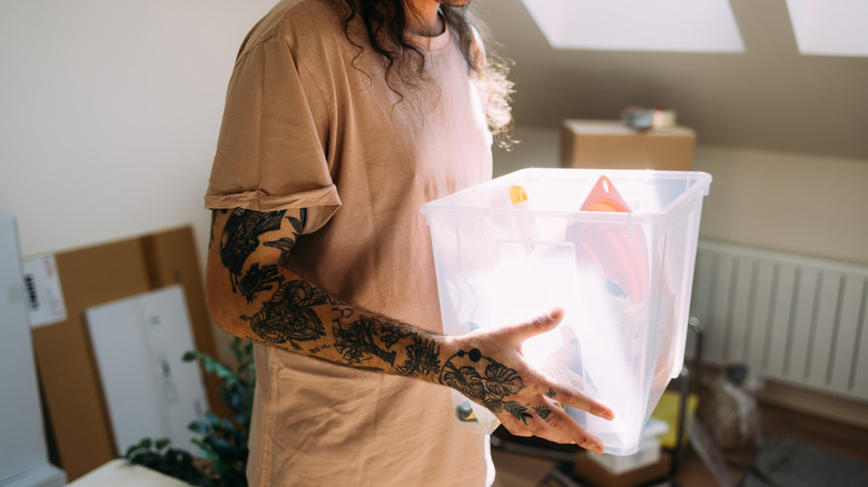 Personne tenant une boîte de rangement en plastique