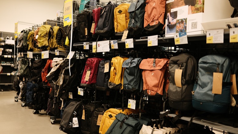 Les supports dans un magasin sont remplis de sacs à dos et de sacs