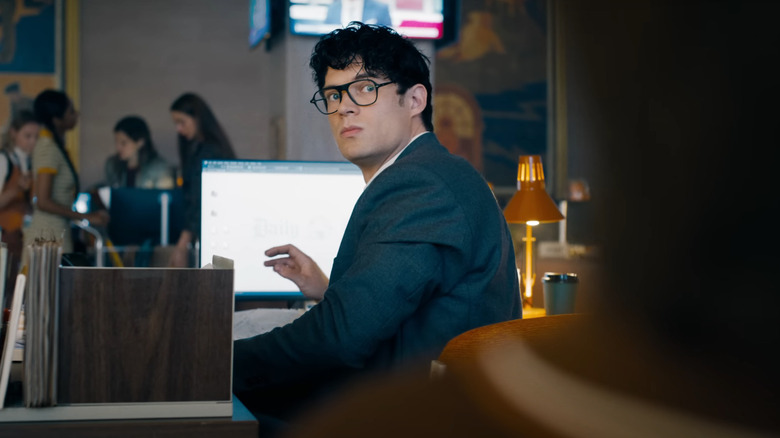 David Corenswet en tant que Clark Kent assis à son bureau au Daily Planet à Superman (2025)