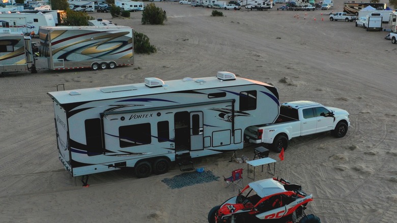 Terrain de camping bondé avec transporteur de jouets et VTT au premier plan