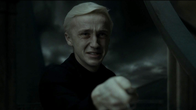 Tom Felton en tant que Draco Malfoy brandissant une baguette à Harry Potter et le prince à demi-sang