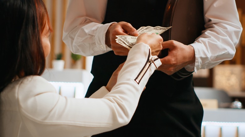 Femme remettant un pourboire à l'hôtel Porter