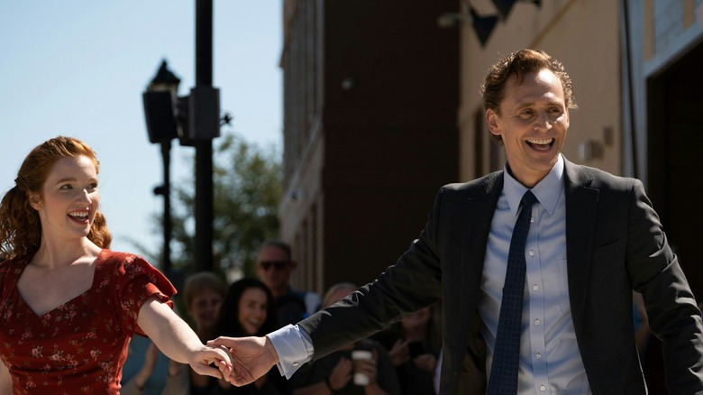 Annalise Basso comme Janet se tenant la main avec Tom Hiddleston comme Charles tout en dansant dans la rue dans la vie de Chuck