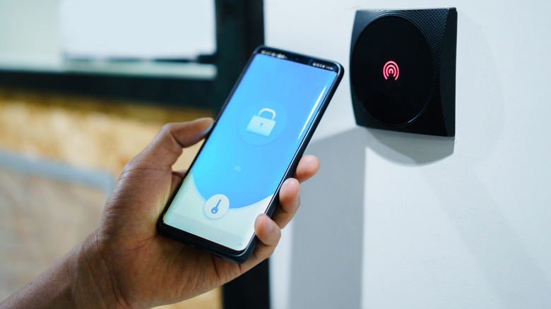 Un homme tenant un téléphone verrouillé dans sa main.