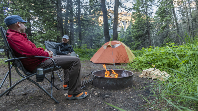 Couple profite d'un feu de camp dans un ring de feu de camp dans le désert